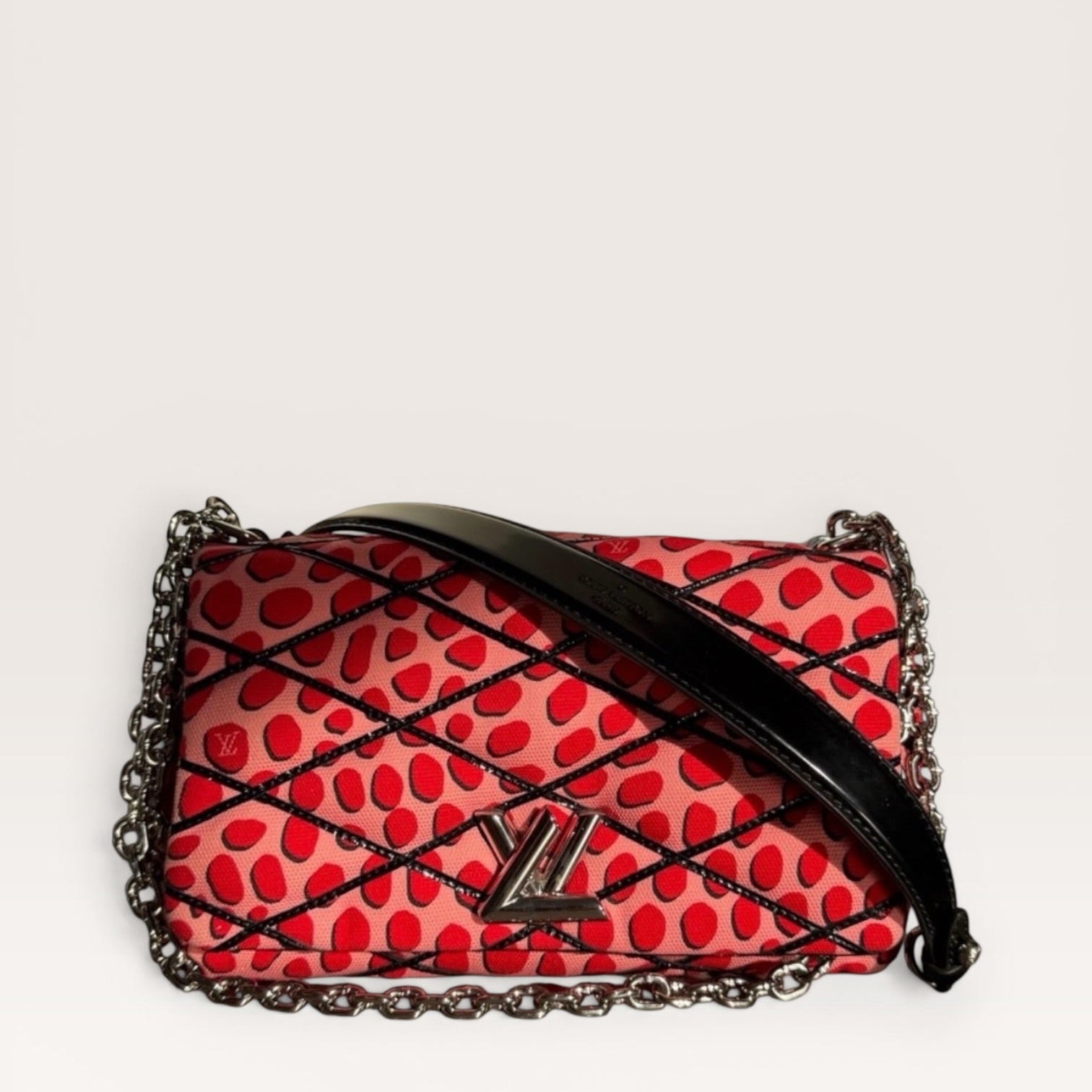 Louis Vuitton LV Twist Jungle Dot Canvas shoulder crossbody bag in pink and red dots with silver chain strap and LV Twist logo closure 