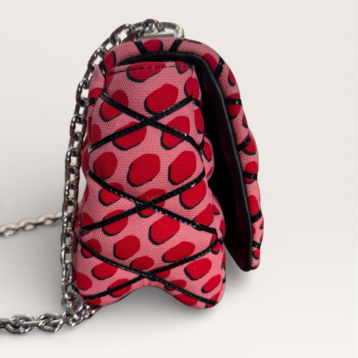 Louis Vuitton LV Twist Jungle Dot Canvas shoulder crossbody bag in pink and red dots side profile showing structured shape and chain strap 
