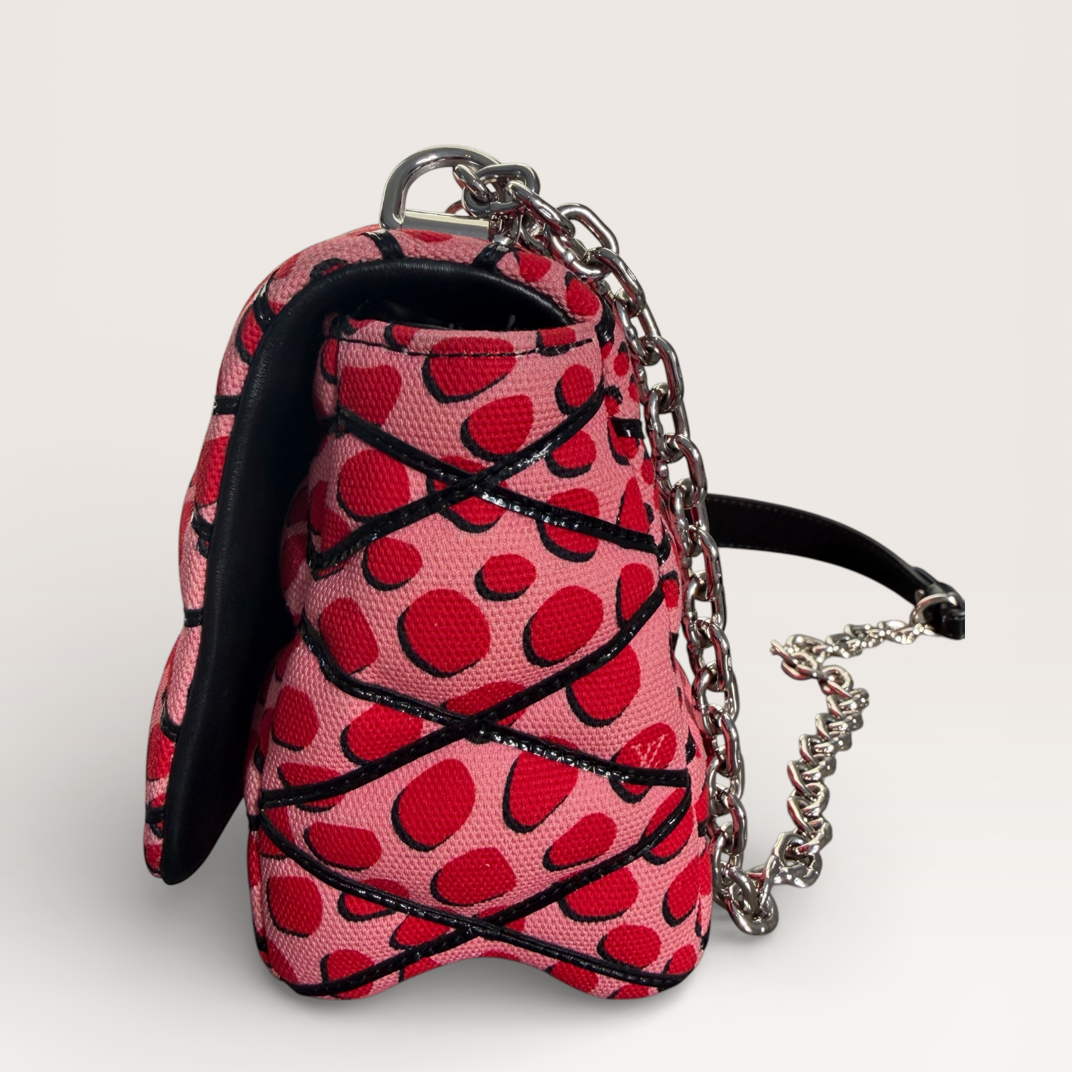 Louis Vuitton LV Twist Jungle Dot Canvas shoulder crossbody bag in pink and red dots side profile showing structured shape and flap