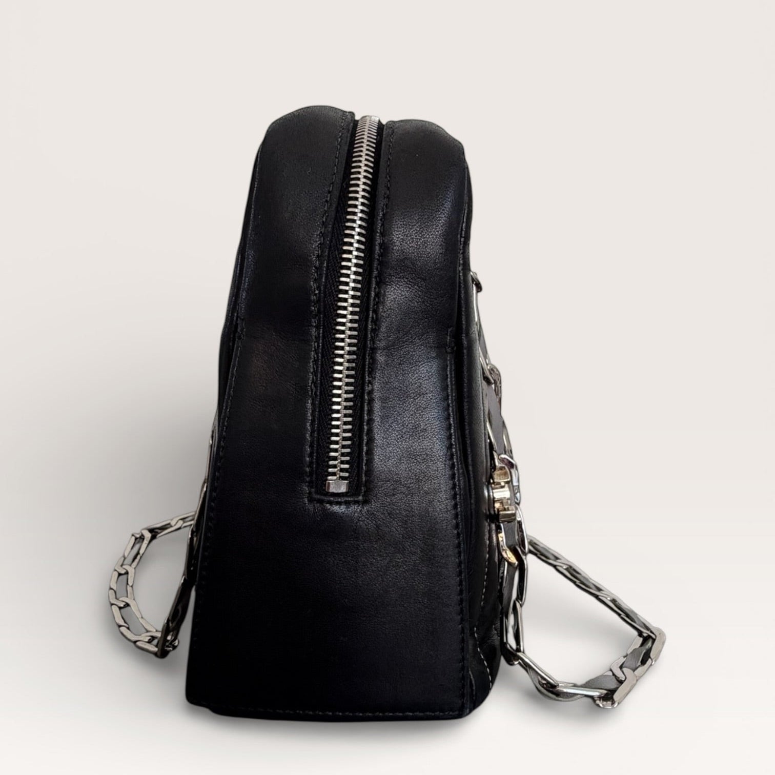 Chanel vintage black quilted leather shoulder bag side view with zip top and silver chain detail